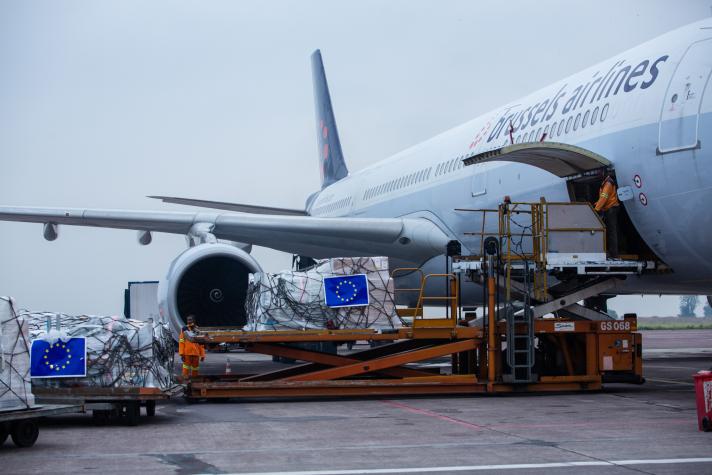 Side of a cargo plane with a hatch open and goods being loaded.