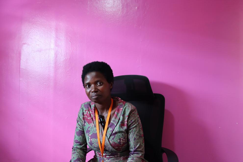 Photo of Emmanuela in front of a bright pink wall.