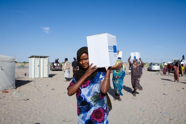 Line of walking women with parcels on their shoulders